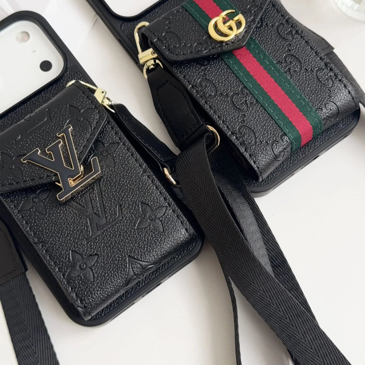Close-up of black GG-pattern phone cases with gold-tone details